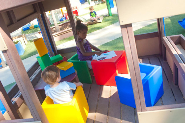 Children's Factory Children's Cube Chairs - 4 Primary Colors, colorful cube-shaped chairs in red, yellow, blue, and green used by children in an outdoor play area.